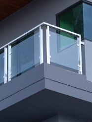 Glass balcony railing with stainless-steel posts on a building facade